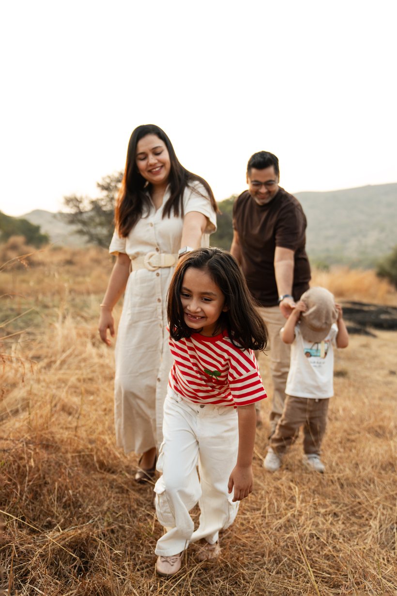 A family walking together through a golden field at sunset